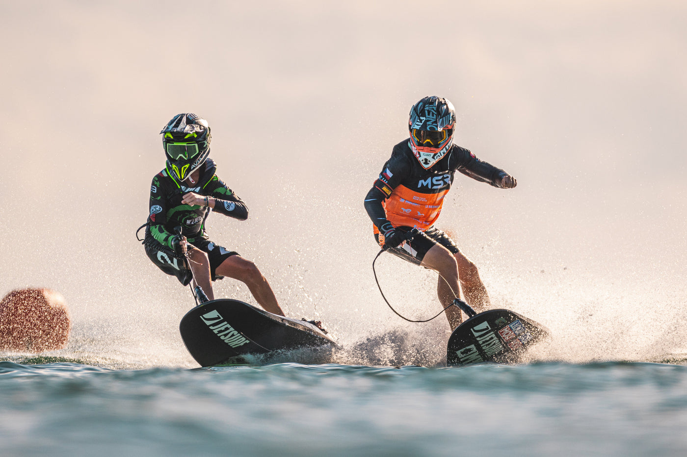 Dos personas con casco montados en su tabla de Jetsurf compitiendo. 